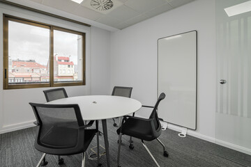 Directors office with a round table and chairs in gray tones in an office meeting room with a large...