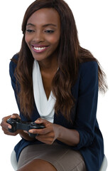 Smiling businesswoman playing video game while sitting on stool