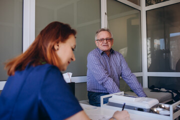 Close up caring nurse holding smiling mature patient hand at meeting in hospital, doctor caregiver...