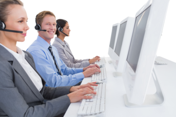 Business team working on computers and wearing headsets