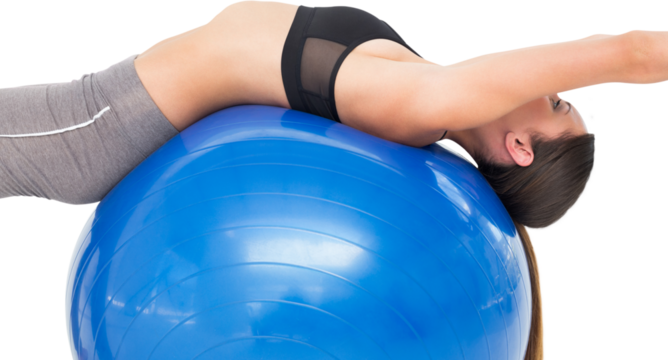 Side view of a fit woman stretching on fitness ball