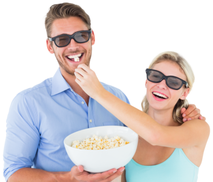 Happy young couple wearing 3d glasses eating popcorn