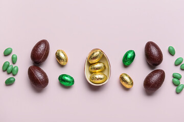 Sweet chocolate Easter eggs and candies on light background