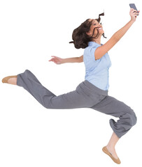 Happy classy businesswoman jumping while holding smartphone