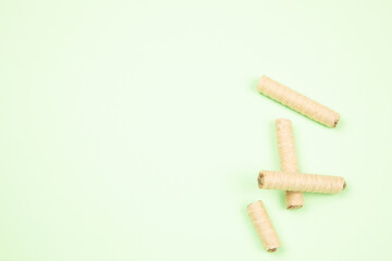 wafer rolls with chocolate isolated on light green background