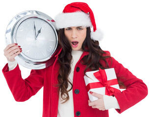 Surprised brunette holding a clock and gift
