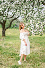 Fototapeta na wymiar girl in a white dress in a spring garden