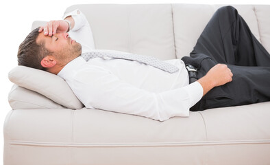 Businessman with headache lying on sofa