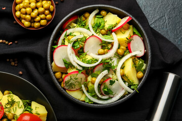 Bowl of tasty Potato Salad with vegetables on dark background