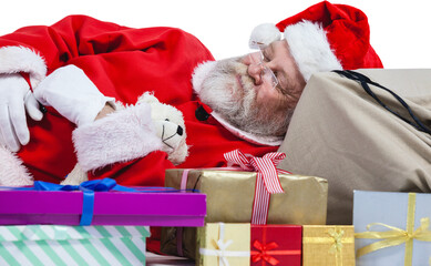 Close-up of tired Santa Claus sleeping beside Christmas presents