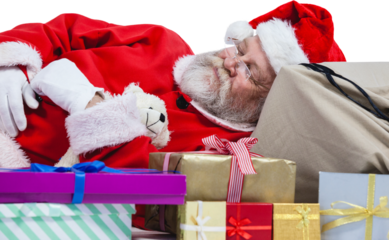 Close-up of tired Santa Claus sleeping beside Christmas presents