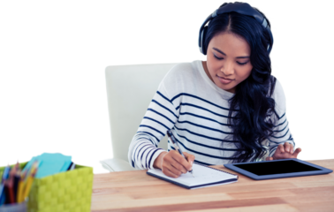 Smiling Asian woman with headphones writing on notepad