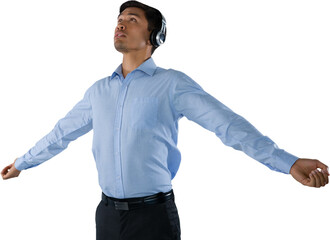 Businessman listening music while standing with arms outstretched