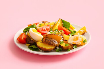 Plate of tasty potato salad on pink background