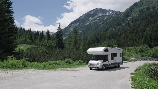 Motorhome camper van vehicle drive on picturesque alps mountain road in slow motion. Family lifestyle trip travel vacation concept.