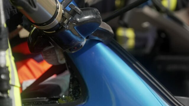 Firefighters cutting the car after accident using hydraulic pilers in slow motion