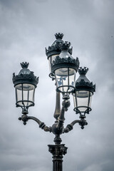 Alte Lampe aus dem 1800er mit einem bewölkten Himmel im Hintergrund