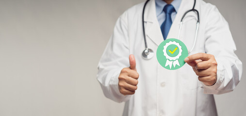 Doctor holding a quality assurance symbol while standing in the hospital