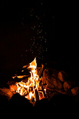Campfire with sparks flying on a dark background at night