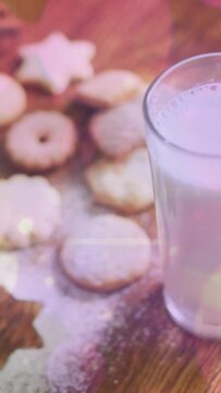 Animation of light spots over milk and cookies at christmas