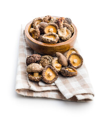 Dried shiitake mushrooms on checkered napkin isolated on white background.