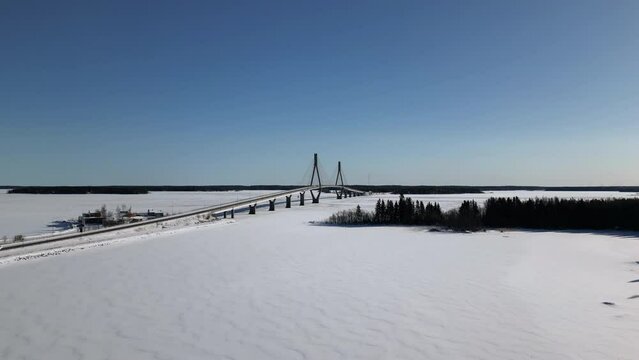 Aerial reveal shot of Frozen lakes and Finland's longest bridge, Raippaluodon silta, in Kvarken archipelago Ostrobothnia Finland on a sunny winter day