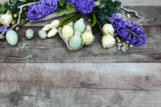  Blumenstrauß mit astellfarbenen Ostereiern auf alten schäbigen Holz, mit Platz für Text.