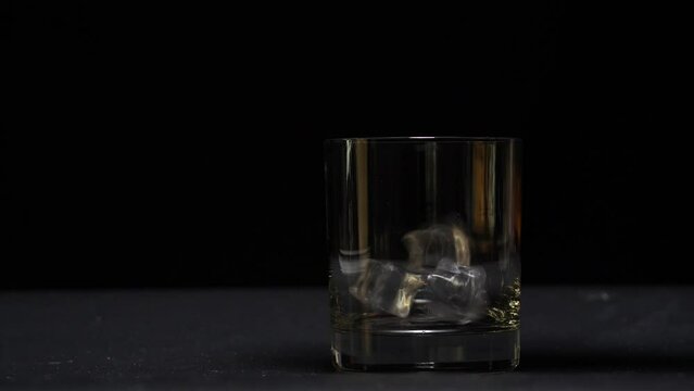 pour whiskey into glass black background