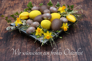 Grußkarte Frohe Ostern: Osternest mit braunen und gelben Ostereiern und der Beschriftung Wir...