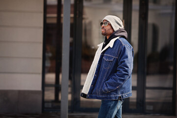Fashionable African american man model wearing stylish outfit denim jacket, hat, hoodie and...