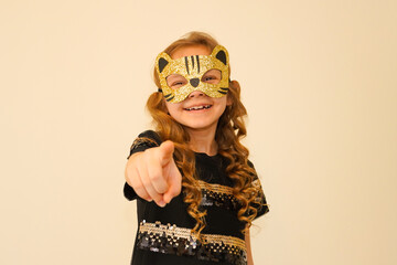 A child in a carnival masquerade mask made by himself. The child is preparing for the festival, party, masquerade, carnival, children's birthday. Hand-made mask from shiny foamiran. 