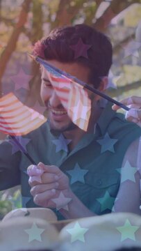 Animation of stars over caucasian family smiling and waving american flags