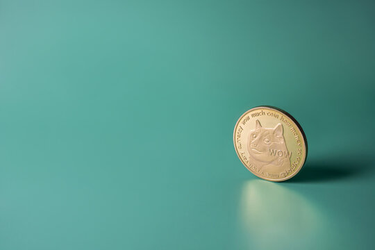 Dogecoin crypto gold single coin on green background with copy space. Popular Doge cryptocurrency banner