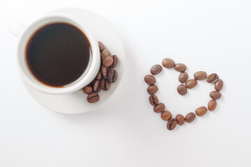 coffee mug with natural coffee beans in the shape of a heart on a white background