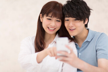 スマートフォンを見るカップル