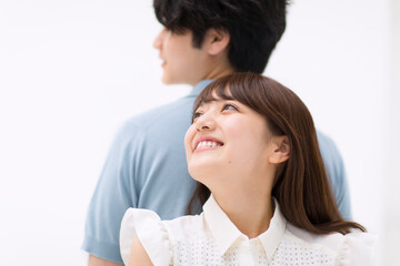 背中を合わせ寄り添うカップル