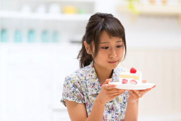 ケーキを食べるのを我慢する女性