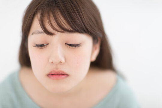 目から涙をこぼす女性
