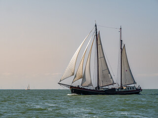 Fototapeta na wymiar Traditional two-masted clipper sailing on IJsselmeer lake, Netherlands