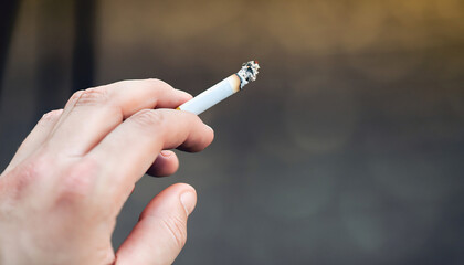 One hand holds a cigarette. Space for text.