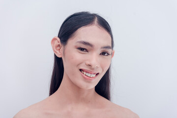 A beautiful Southeast Asian transwoman smiling for the camera for a photo shoot of a whitening product. Model of cosmetics products. Studio shot isolated on a white background.