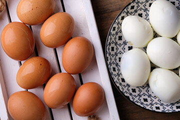 chicken eggs on a wooden cutting board. and boiled chicken eggs on ceramic plate. source of animal protein. Telur rebus. 