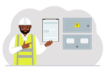 A male electrical engineer holds a clipboard with a contract and stands next to an electrical cabinet. The concept of a contract for service, connection of electricity or hiring a specialist.