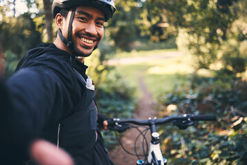 Selfie, cycling and smile with man in nature for social media, training and workout. Happiness, internet and exercise with portrait of cyclist on bike in forest park for adventure, cardio and picture