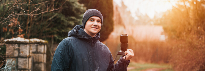 Man photographer with modern mirrorless camera outdoor. Photographer website banner concept.