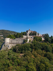 Fototapeta na wymiar Vertical panoramic view from a drone of a hill (colle Cidneo) with park and historical castle in the Brescia town. Lombardy, Italy