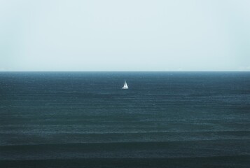 View of a white boat sailing in the blue ocean before the horizon