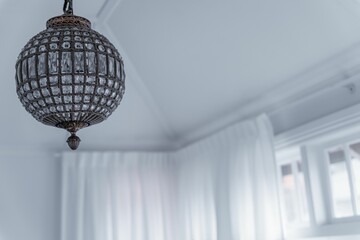 Obraz premium Low-angle view of a circle glass-designed chandelier hung from the ceiling of a room