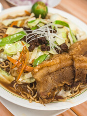 Pancit Cabagan, a dish originating from Isabela, Philippines. Stir fried noodles soaked in sauce, topped with vegetables and pork.