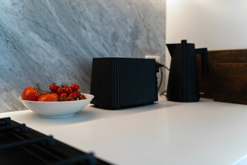 Modern kitchen with tomato bowl by a black cooktop